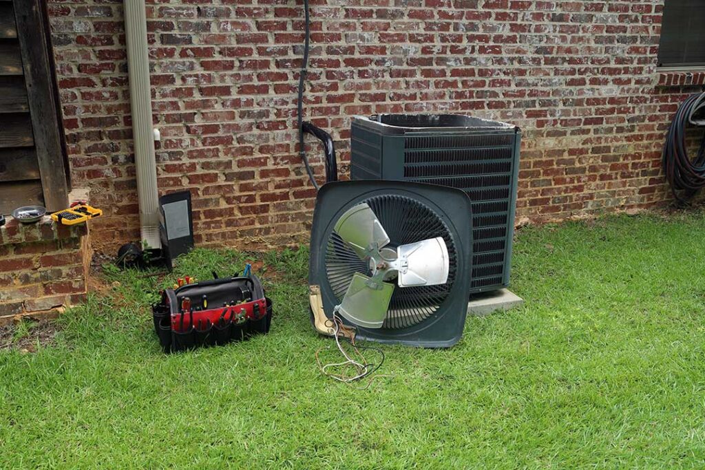 A homeowner checks and replaces a furnace air filter in a basement utility area.