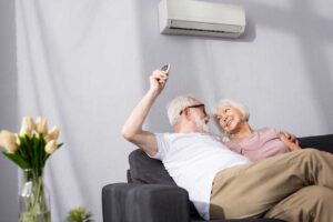 A person changing a furnace air filter in a residential basement utility area.